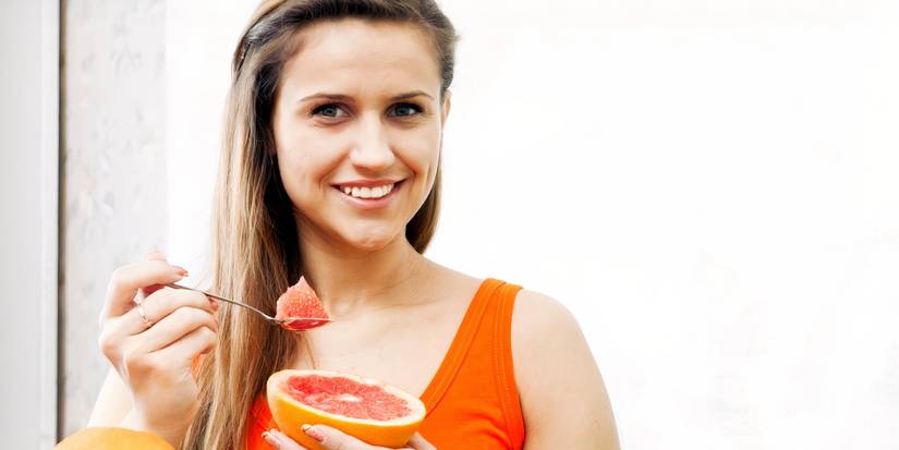 Femme mange du pamplemousse