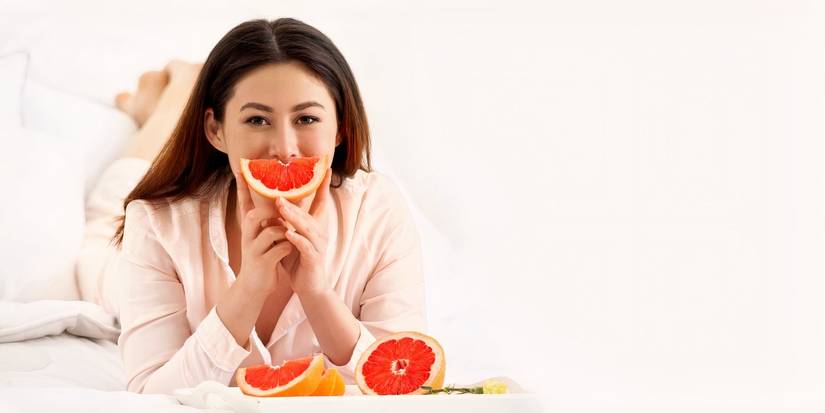 Femme mangeant un pamplemousse