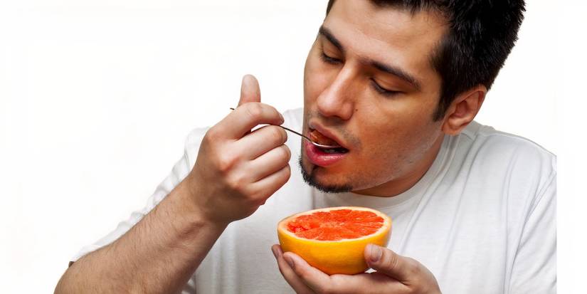 Homme mangeant du pamplemousse