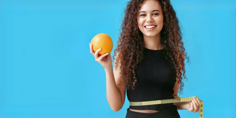 Femme souriante tenant un pamplemousse