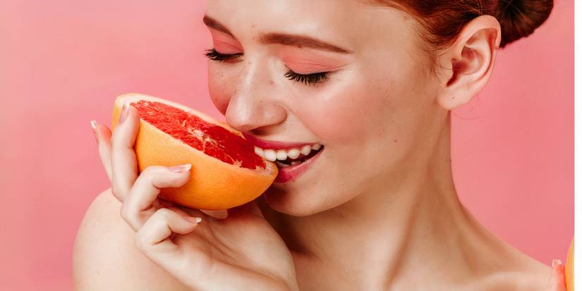 Belle femme mangeant du pamplemousse