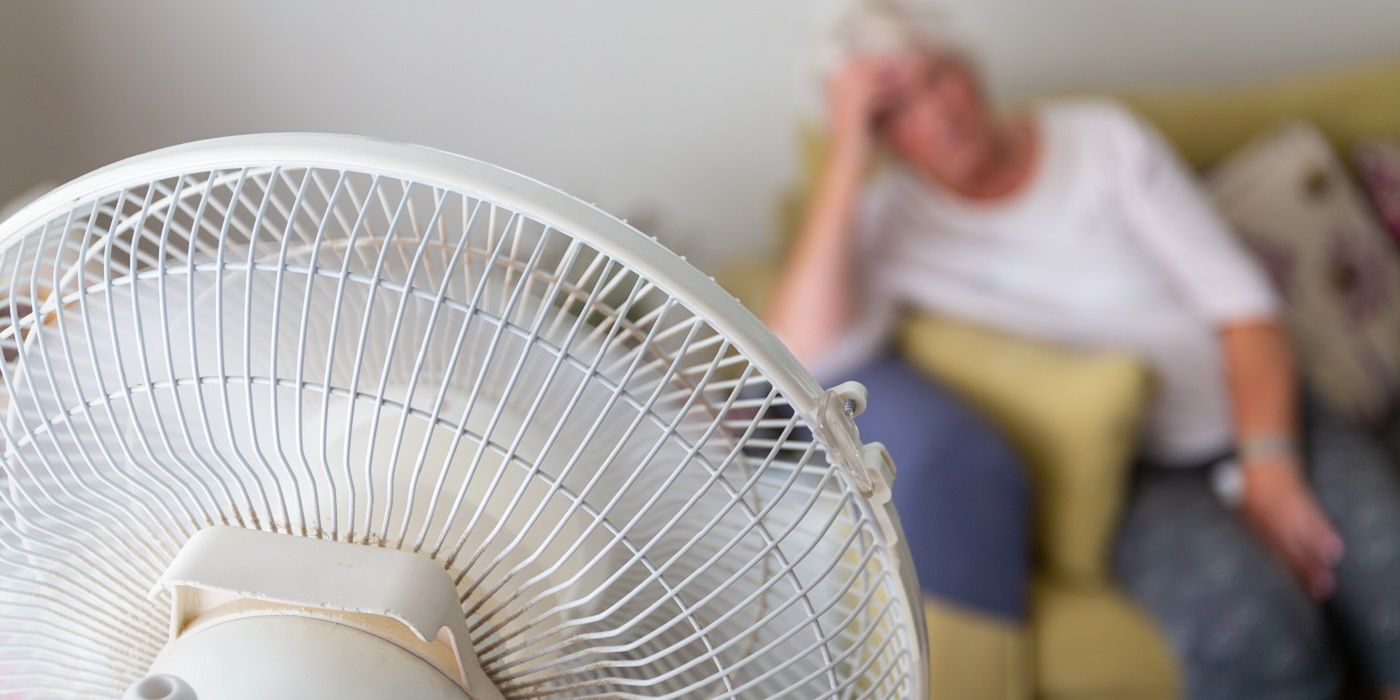 Personne assise devant un ventilateur de table